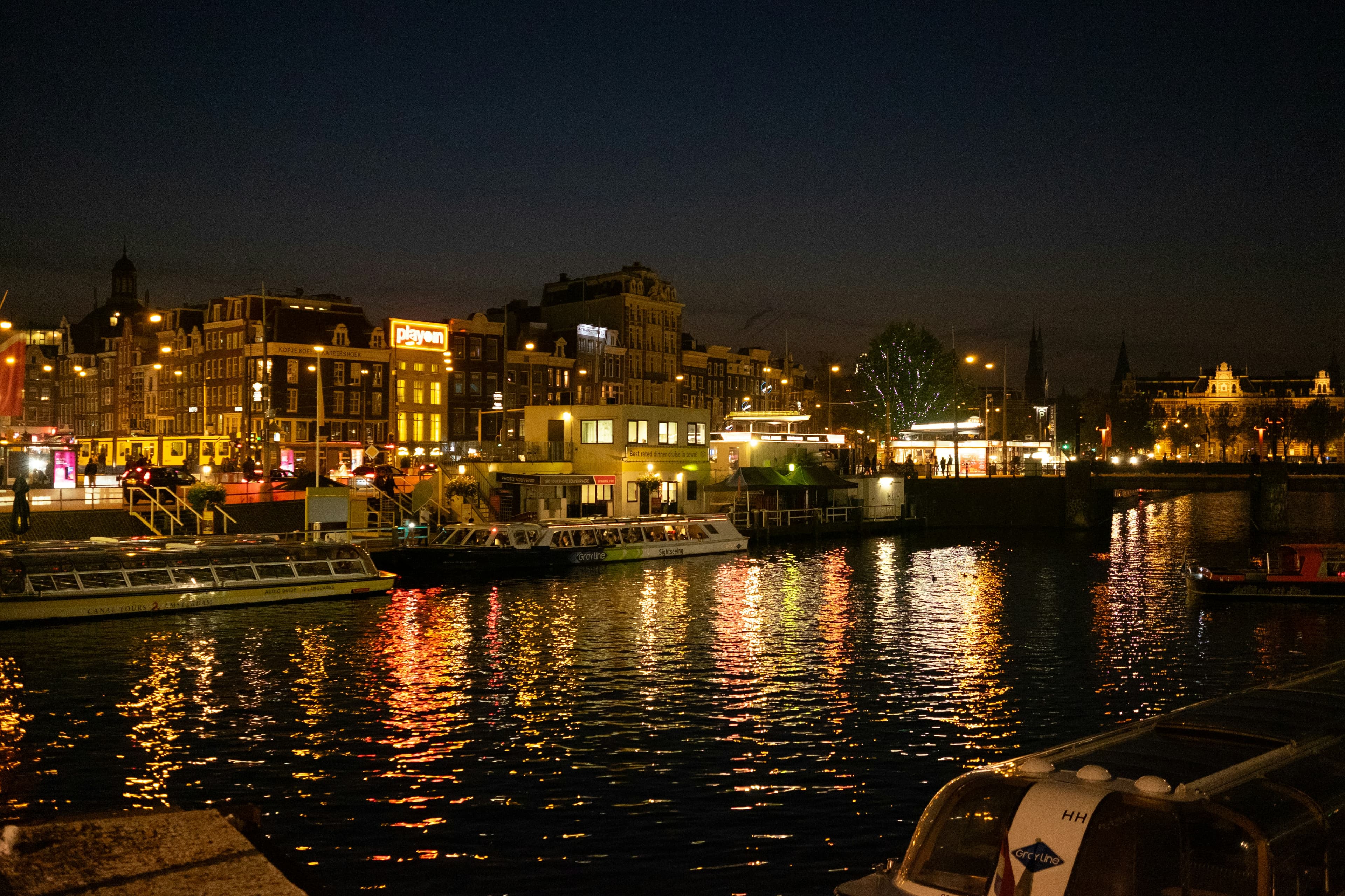 Amsterdam skyline at night, dark atmospheric cityscape, deep shadows, low-key urban lighting